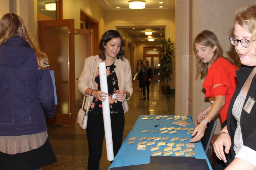 Image 1 of 15 People gathered around the welcome table, looking at nametags